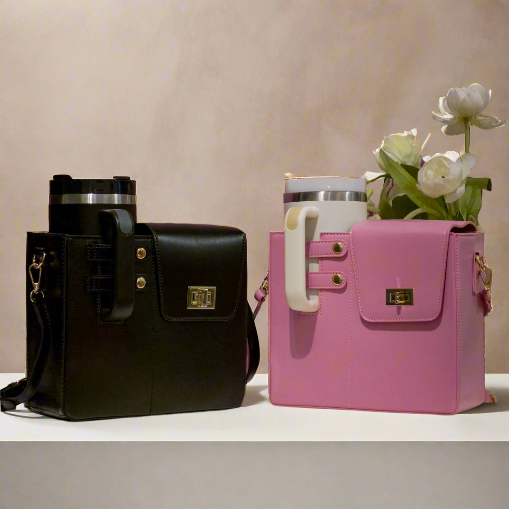 Black handbag and pink suitcase with floral arrangement on a patterned wall background