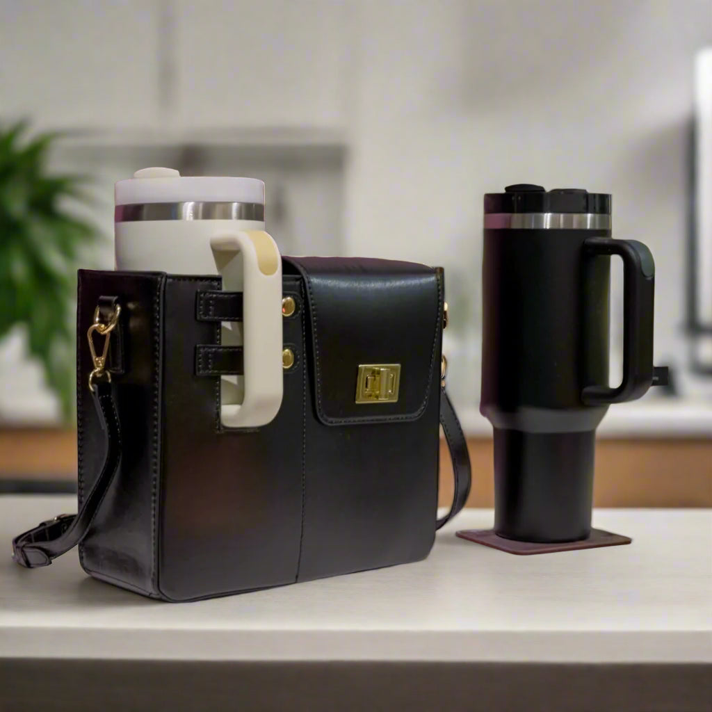 Black leather bag with a white handle next to a black thermos on a table with a purple patterned wall in the background.