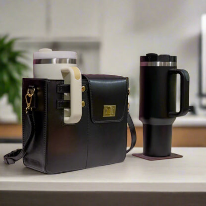 Black leather bag with a white handle next to a black thermos on a table with a purple patterned wall in the background.